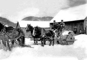 Roy Eurich and Charles Patterson rolling snow in 1925. Charles lived on the farm that would later become the Common Man Restaurant on German Flats Road. This photo was taken on that farm.