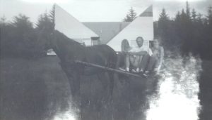 Lenord Robinson and children in a horse drawn carriage, after construction of their home.